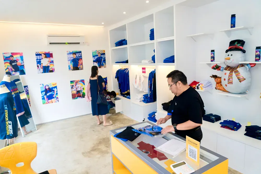 A man is standing at a counter in a store.
