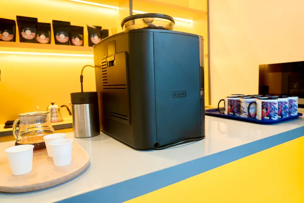 A coffee machine is sitting on a counter next to a tray of cups.