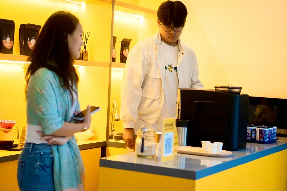A man and a woman are standing at a counter in a restaurant.