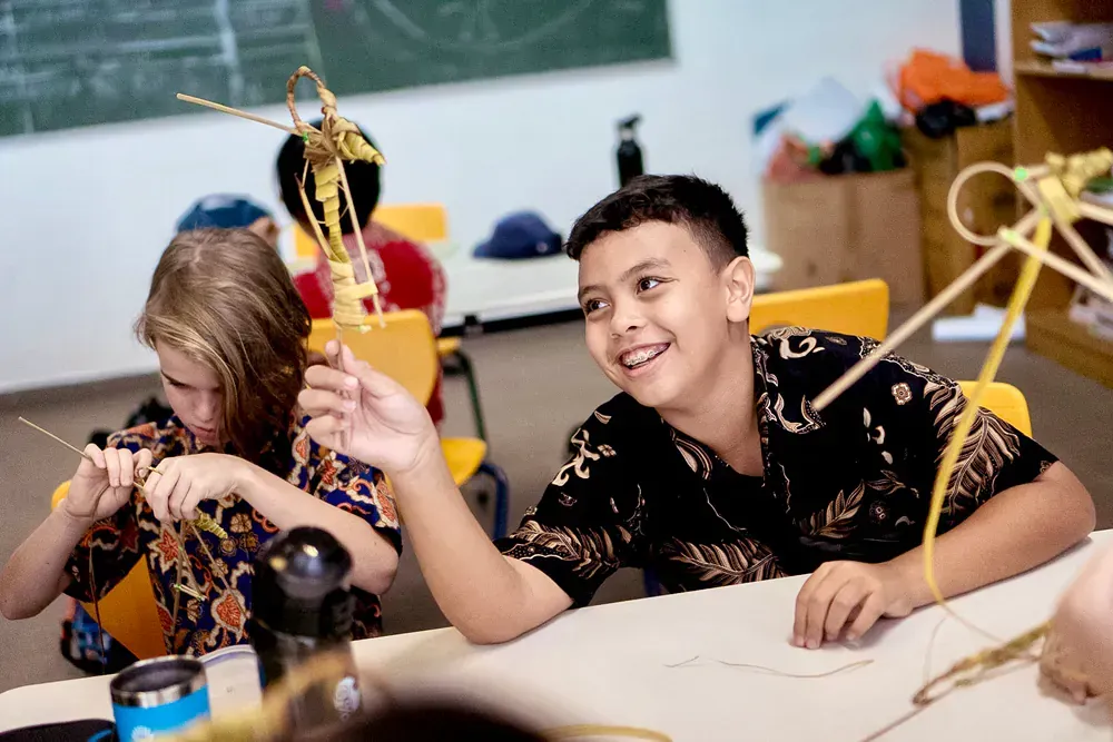 A boy and a girl are sitting at a table in a classroom.