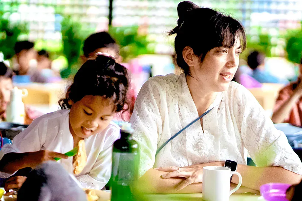 A woman and a child are sitting at a table in a restaurant.