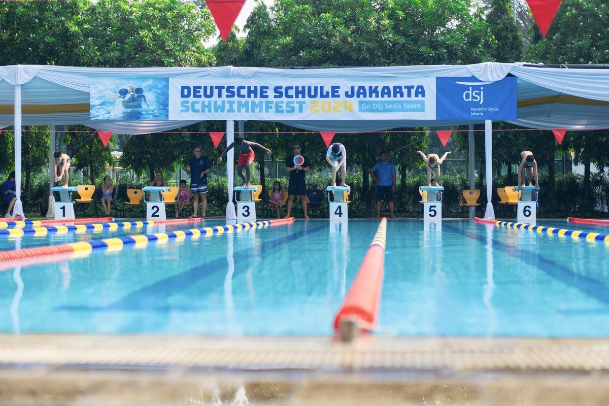 A swimming pool with a sign that says deutsche schule jakarta