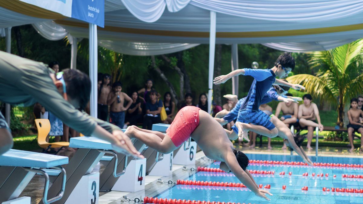 A group of people are swimming in a pool.