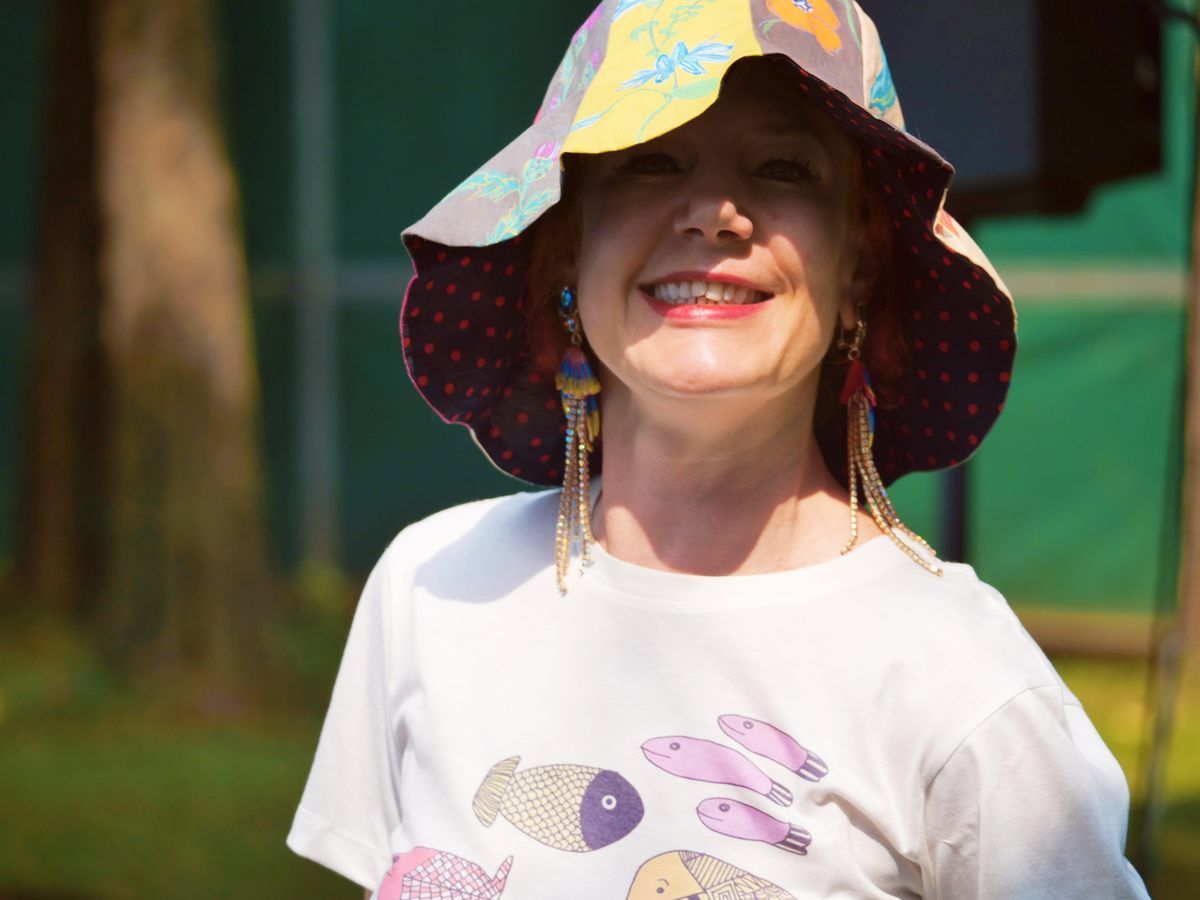 A woman wearing a hat and a white shirt with fish on it