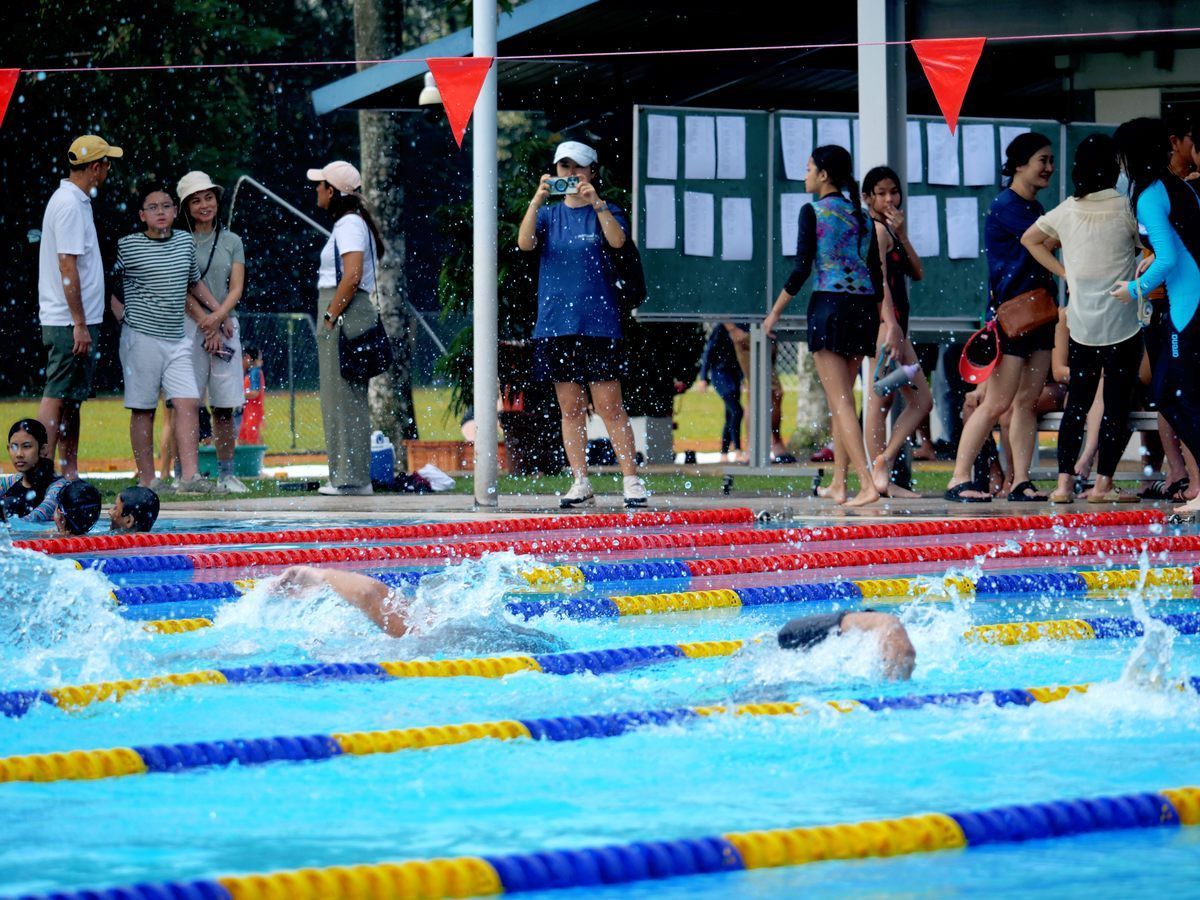A group of people are standing around a swimming pool