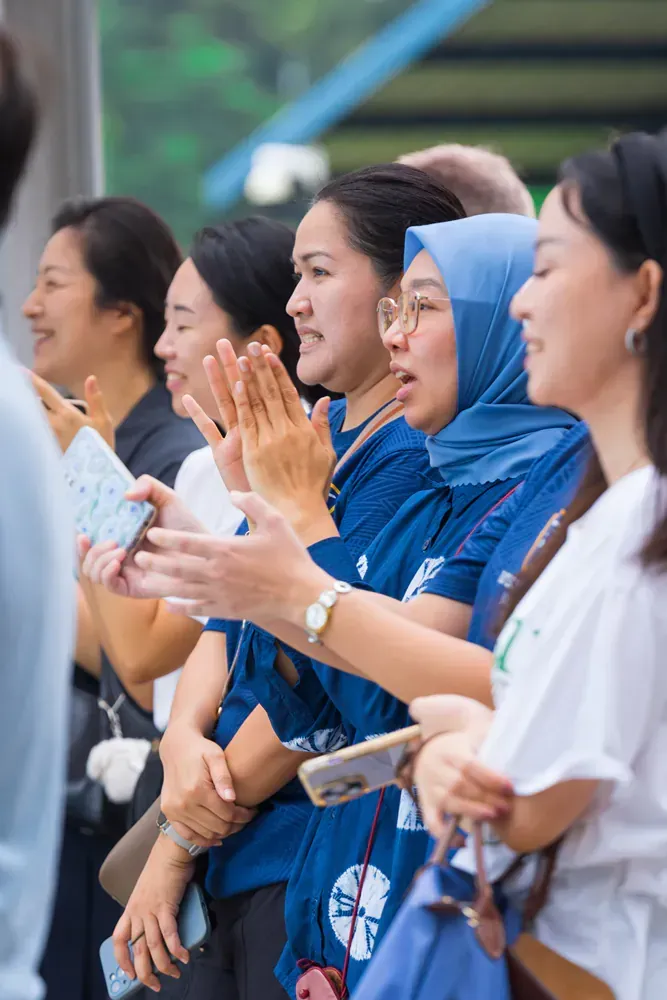 A group of women are standing in a line applauding.