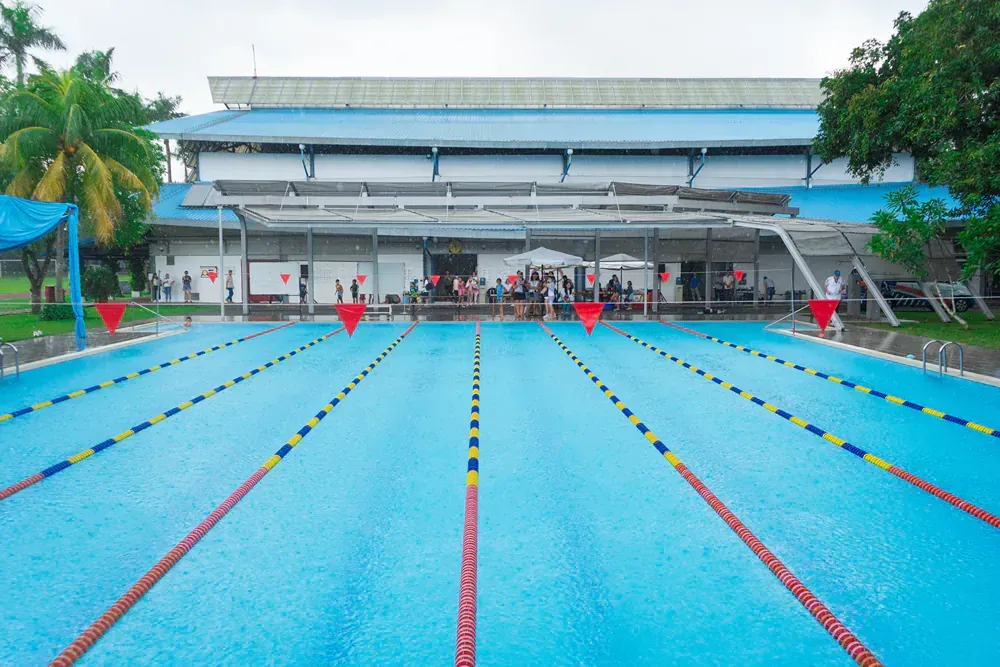 A large swimming pool with a large building in the background.