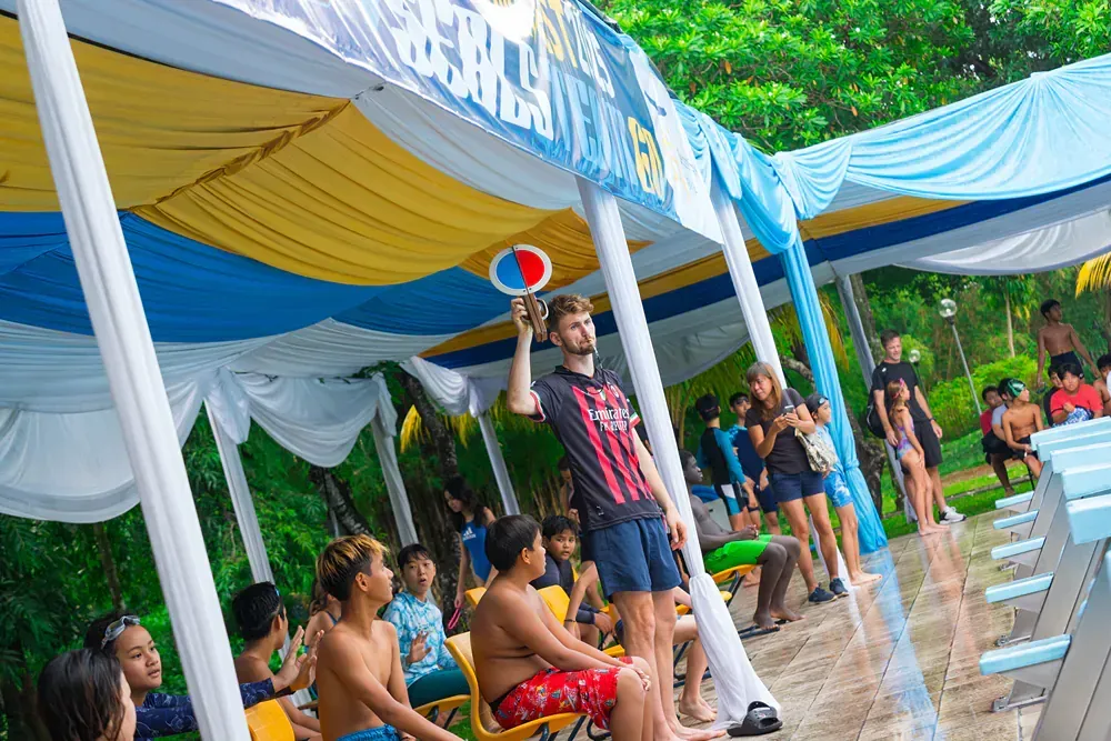 A group of people are sitting under a tent at a water park.