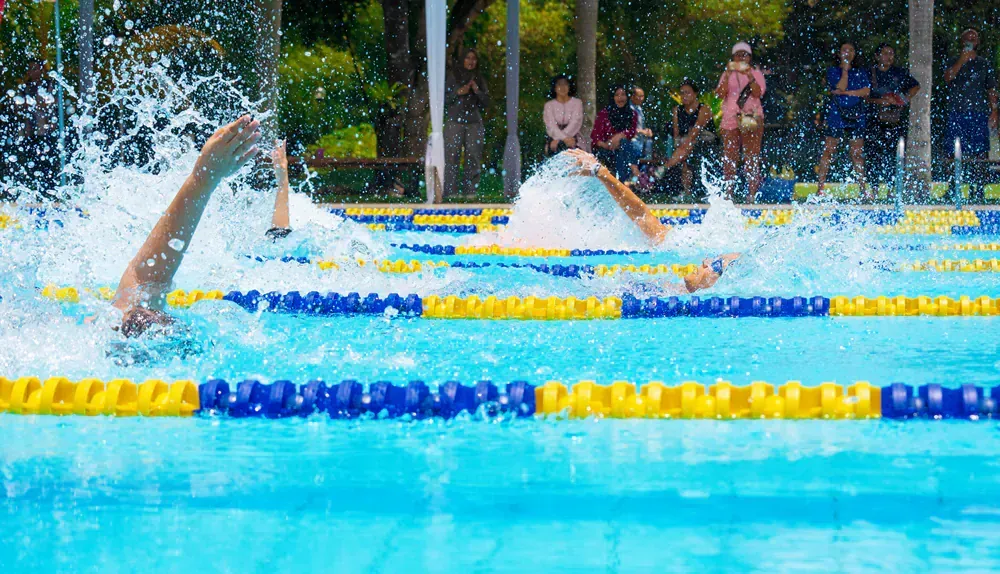 A group of people are swimming in a swimming pool.