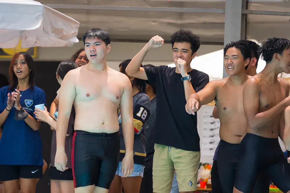 A group of young men are standing next to each other in a swimming pool.