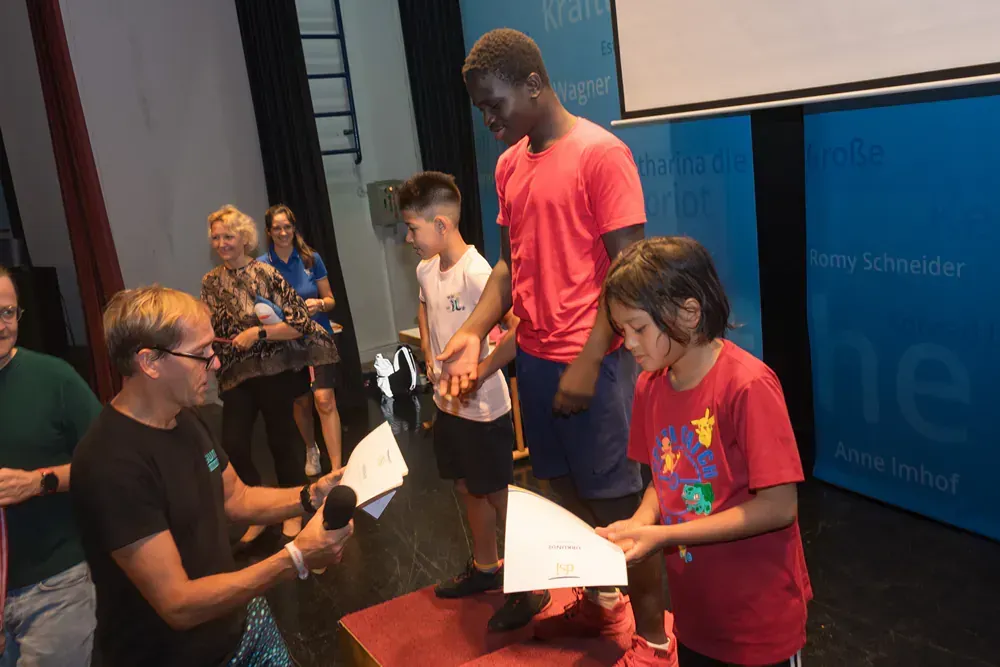 A group of people are standing around a table holding papers.