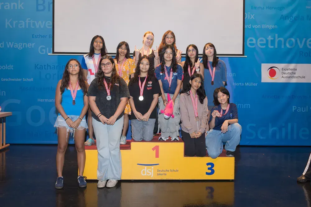 A group of young women are posing for a picture on a podium.