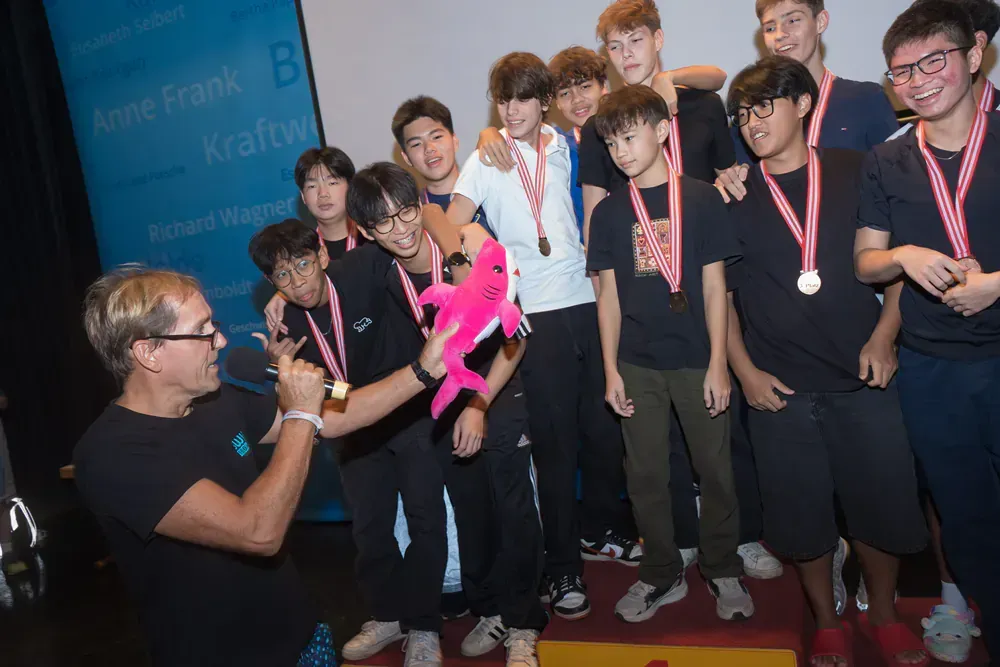 A group of young men are posing for a picture with medals around their necks.