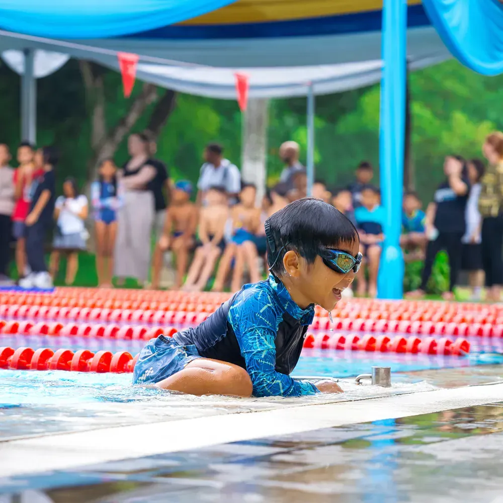 A young boy is swimming in a swimming pool.