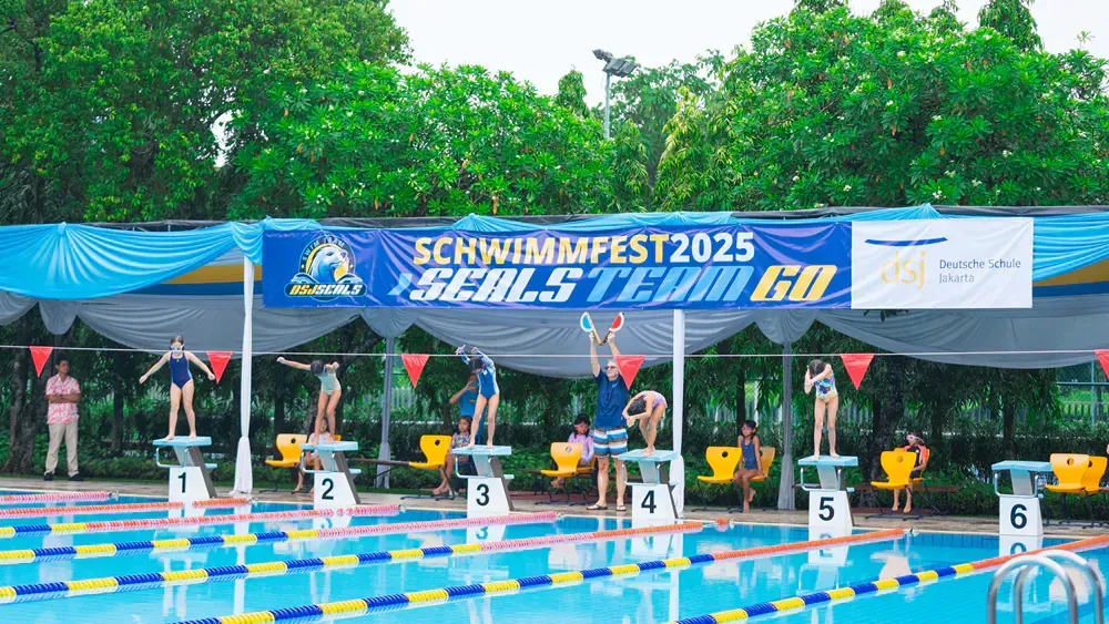 A group of people are jumping into a swimming pool.