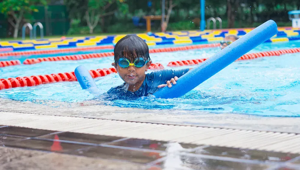 A young boy is swimming in a swimming pool with a float.