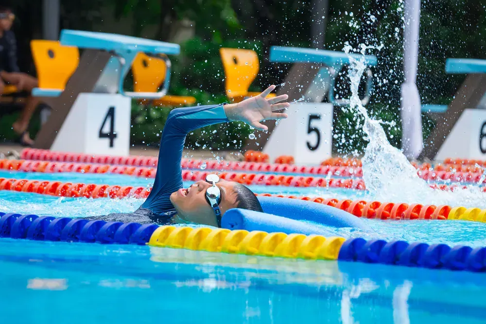 A person is swimming in a swimming pool.