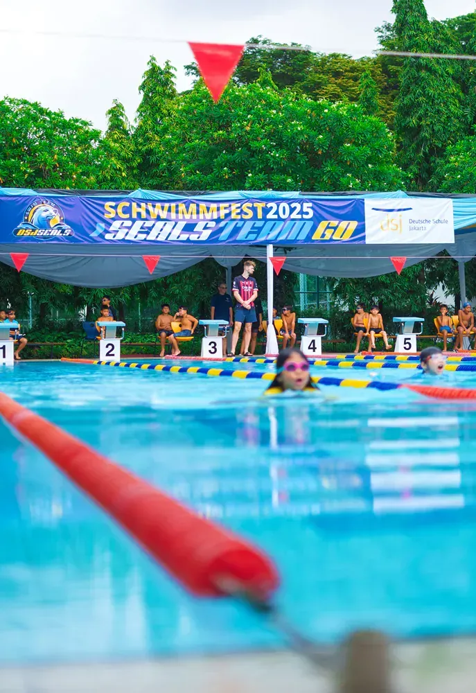 A group of people are swimming in a swimming pool.