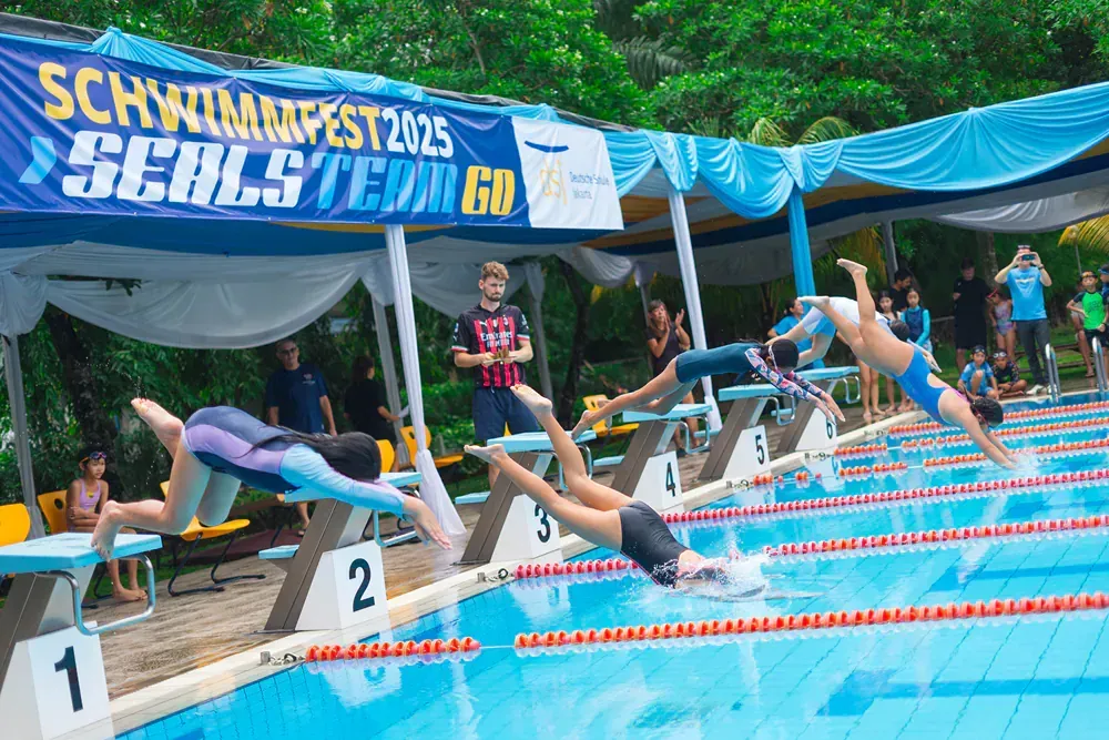 A group of people are swimming in a pool.