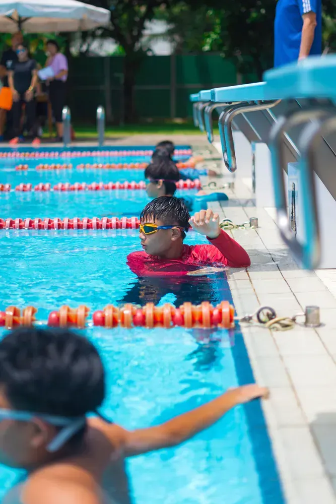 A group of children are swimming in a swimming pool.