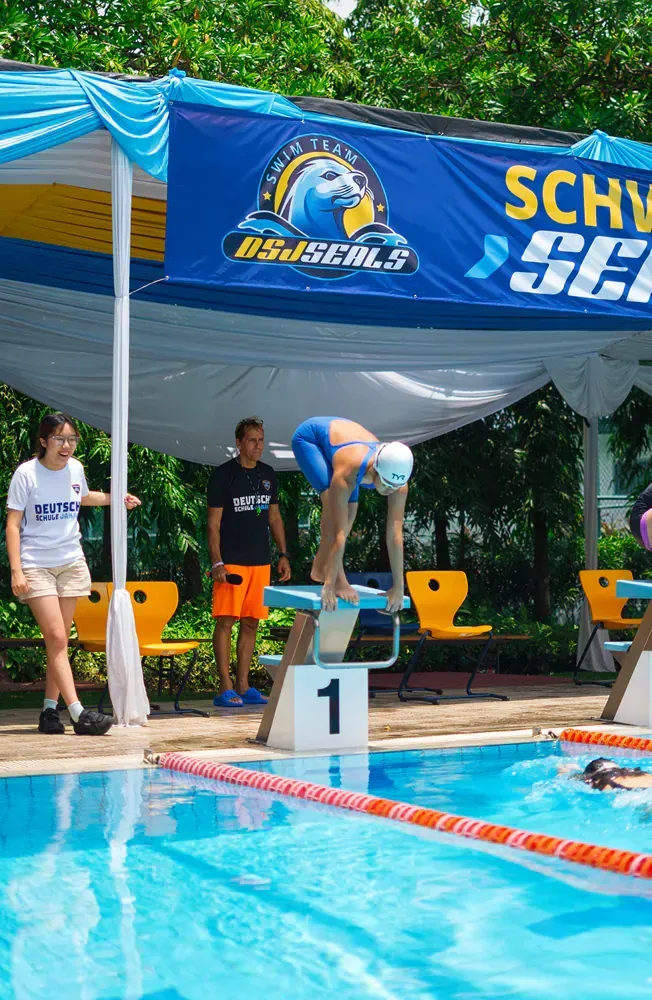 A woman is getting ready to dive into a swimming pool.