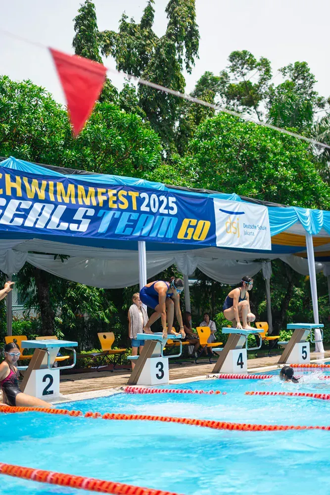 A group of people are getting ready to swim in a swimming pool.