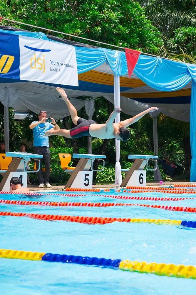 A person is doing a flip in a swimming pool.