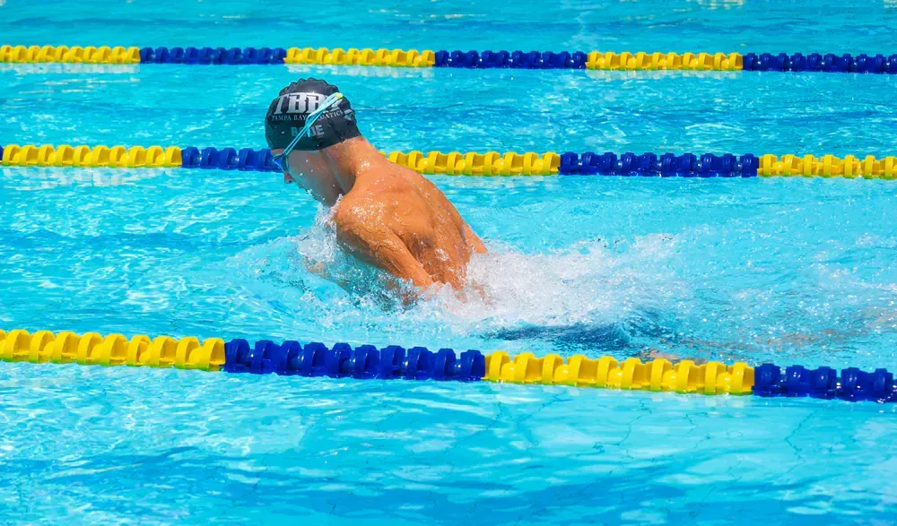 A man is swimming in a swimming pool.