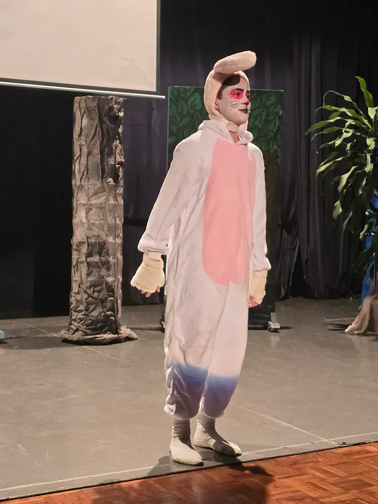 A person in a bunny costume is standing on a stage.