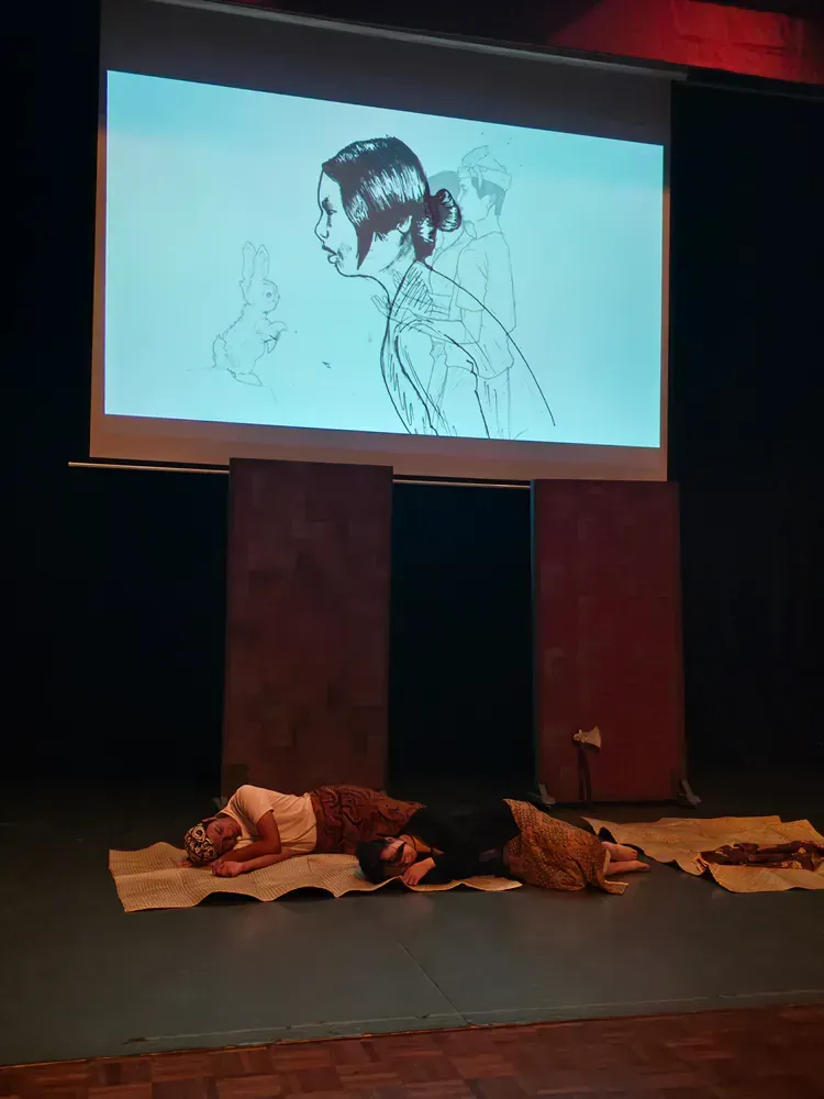 Two people laying on the floor in front of a projector screen