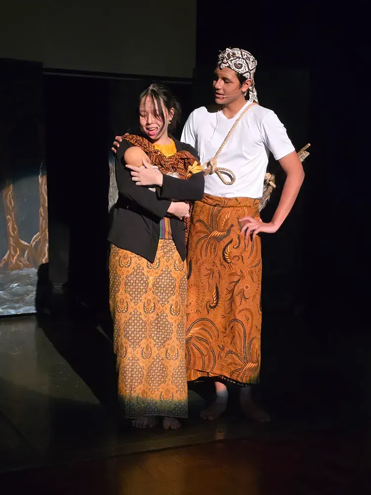 A man and a woman are hugging each other on a stage