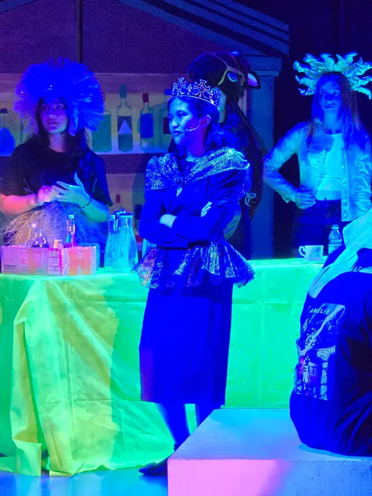 A group of people are standing around a table in a dark room.