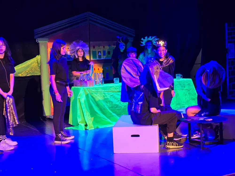 A group of people are standing on a stage with glow in the dark lights.