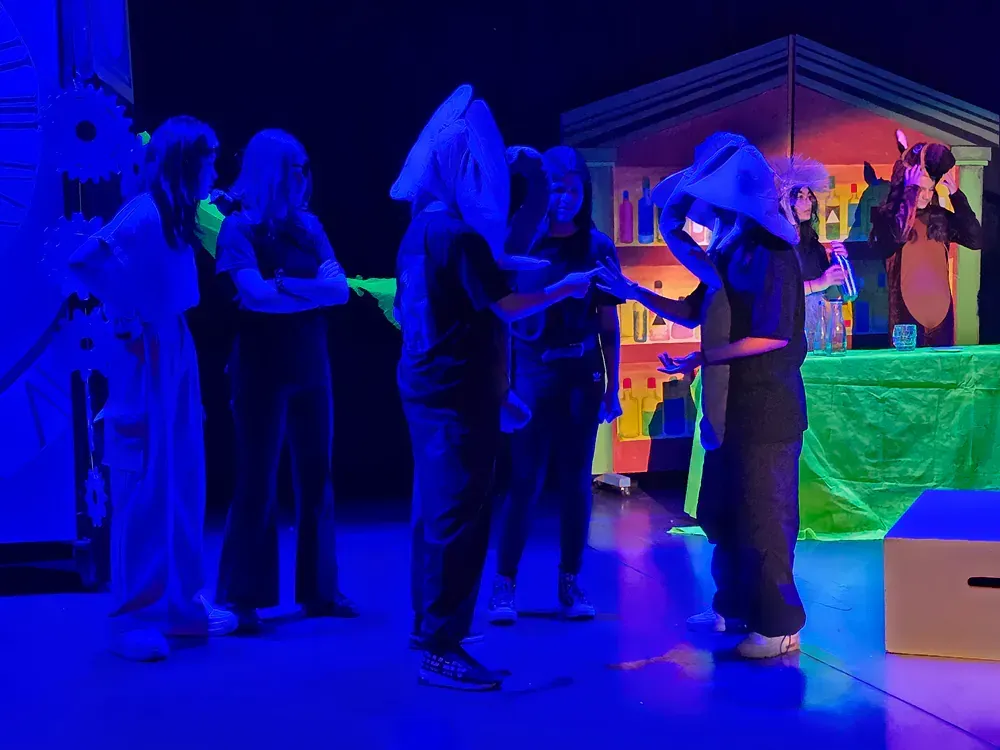 A group of people are standing on a stage in a dark room.