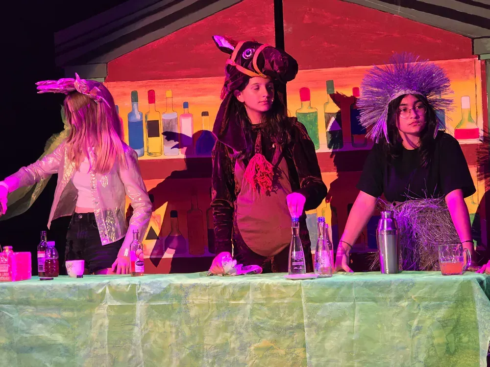 A group of young women are standing around a table.