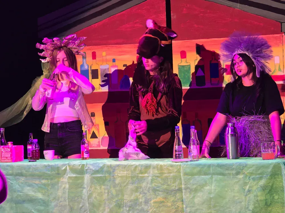 A group of people are standing around a table in a dark room.