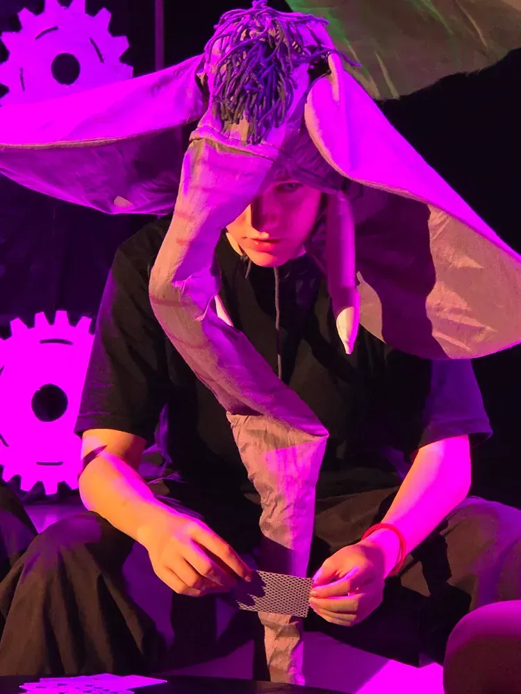 A man in an elephant costume is holding a piece of paper