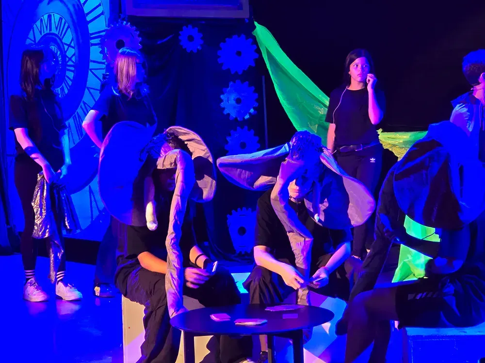 A group of people are sitting around a table in a dark room.