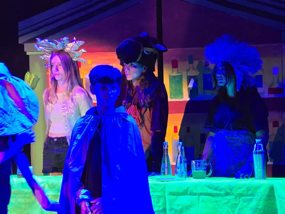 A group of people are standing on a stage with glow in the dark lights.