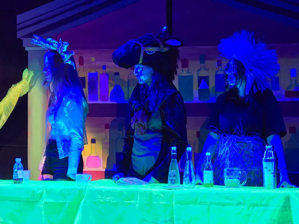 A group of people are standing around a table in a dark room.