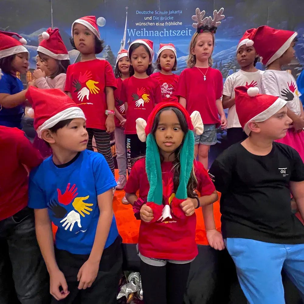 A group of children wearing santa hats are posing for a picture.