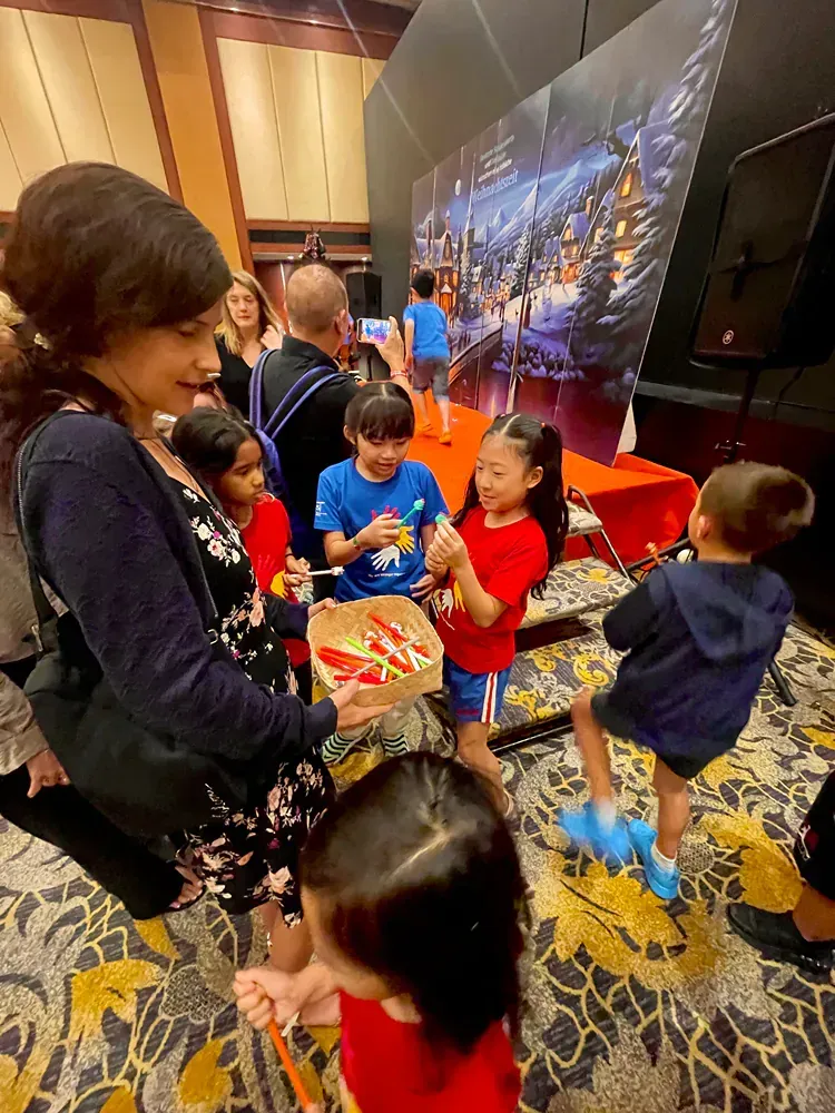 A woman is talking to a group of children in a room.