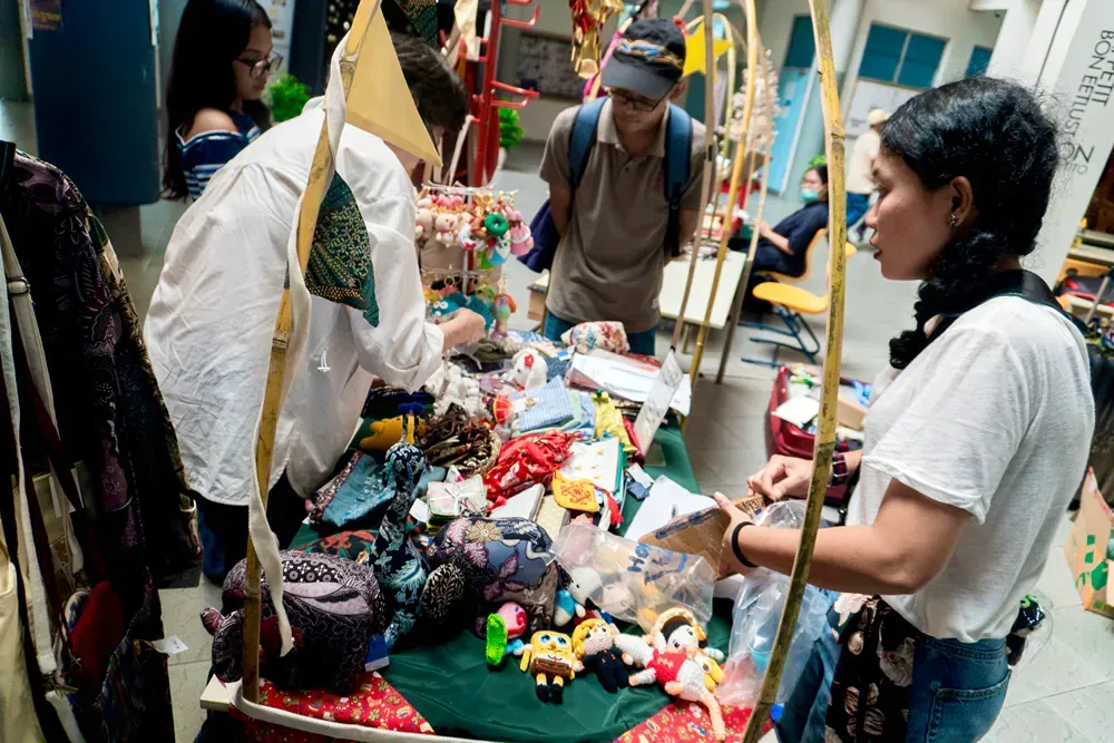 A group of people are standing around a table with toys on it.