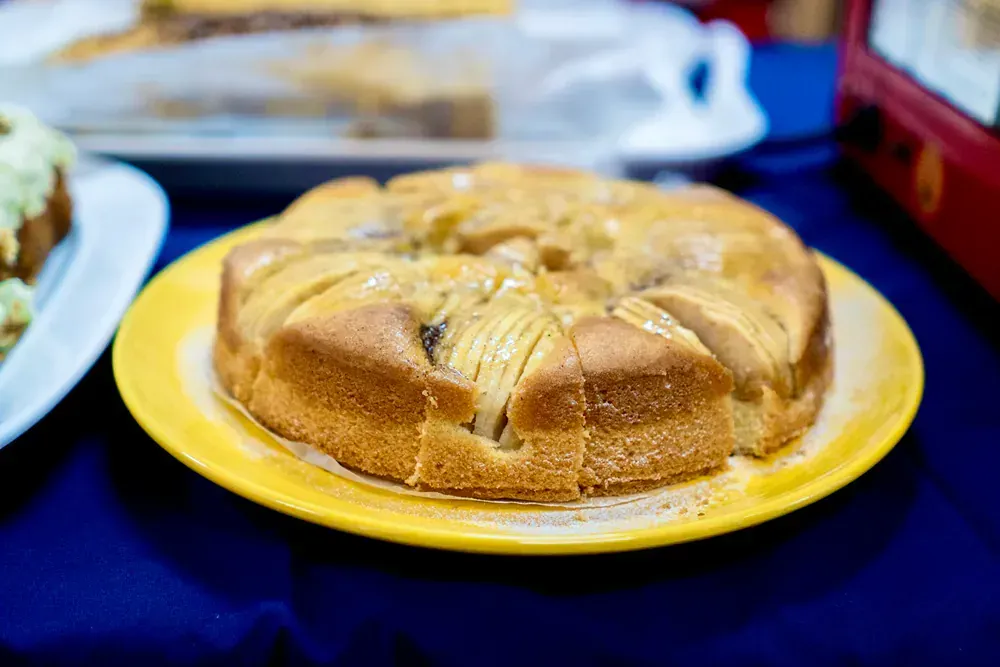 An apple pie is on a yellow plate on a table.