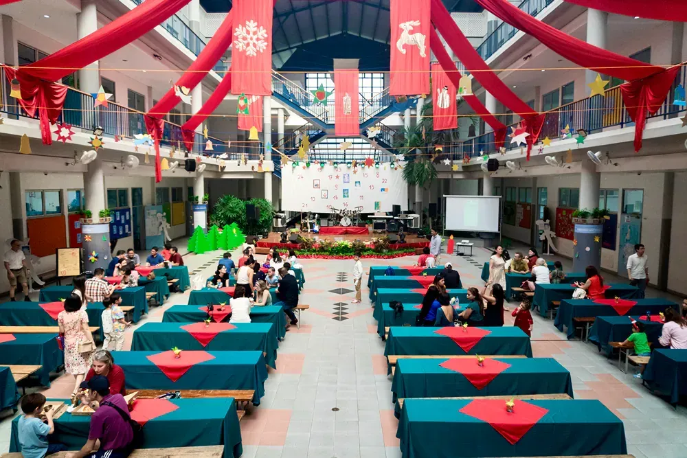 A group of people are sitting at tables in a large room.