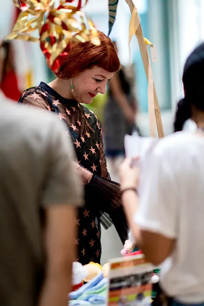 A woman wearing a christmas hat is standing in a crowd of people.