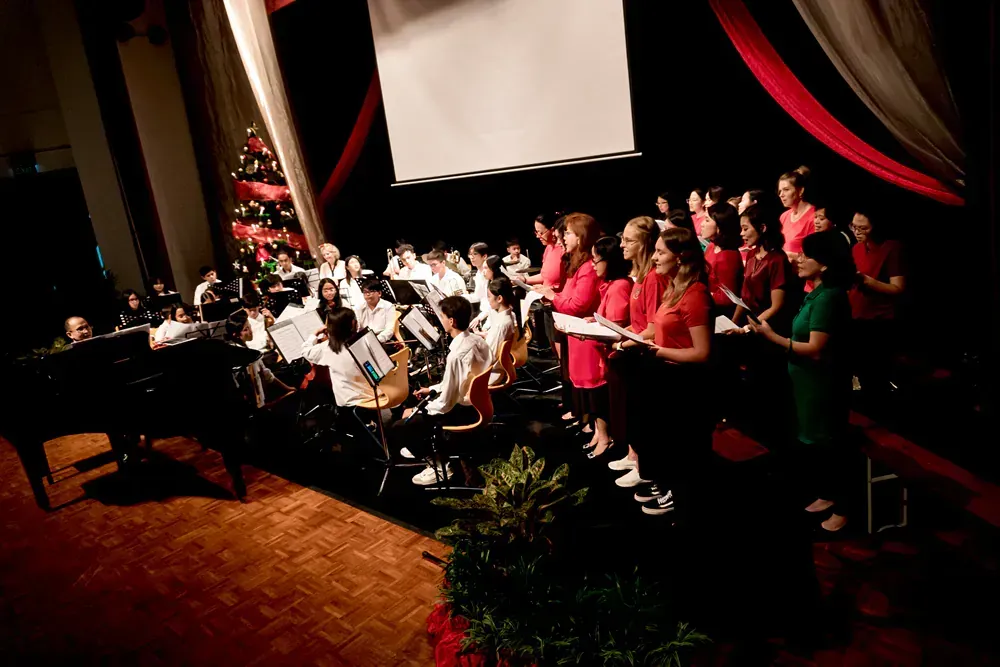 A large group of people are singing on a stage.