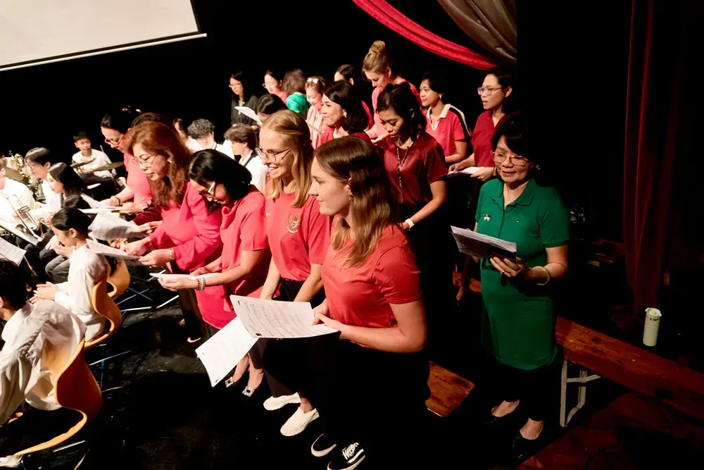 A group of people are singing in a choir on a stage.