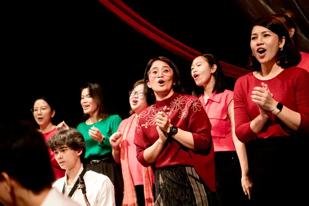 A group of women are singing together on a stage.