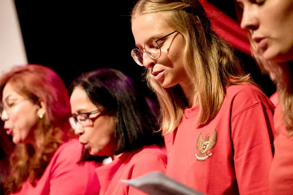 A group of women are singing together in a choir.